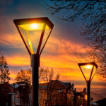 Lampadaire extérieur sur poteau, tête carrée en verre, lumière ambre chaude, mât métal noir