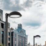 Lampadaire extérieur noir à tête plate ronde sur poteau en métal