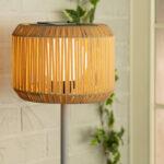 Lampadaire extérieur à abat-jour tressé beige sur mât métal gris
