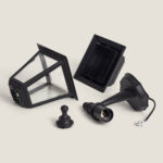 Applique murale extérieure noire démontée, lanterne en métal et verre avec base et câble visibles