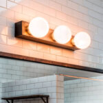 Applique murale trois globes en verre opalin sur plaque métallique finition bronze