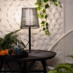 Lampe à poser extérieure noire, pied fin métal et abat-jour ajouré cylindrique, conçue pour table d'extérieur