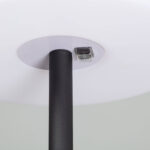 Lampe à poser extérieure abat-jour rond blanc, pied cylindrique noir mat et module rectangulaire visible sous l'abat-jour