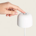 Lampe à poser blanche forme cloche avec bouton tactile circulaire sur le dessus et câble d'alimentation