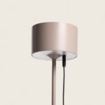 Lampe à poser ronde beige rosé sur pied avec abat-jour cylindrique et câble de recharge USB visible