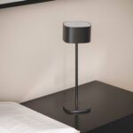 Lampe à poser noire avec abat-jour cylindrique, pied fin et base arrondie