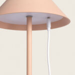 Lampe à poser beige avec câble USB branché, abat-jour conique et pied fin métallique