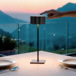 Lampe à poser noire en métal, abat-jour cylindrique, tige fine et base carrée, usage extérieur sur table