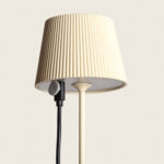 Lampe à poser beige, abat-jour plissé, pied fin métal et câble latéral avec interrupteur