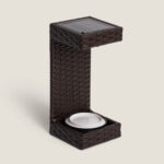 Lampe à poser extérieure en résine tressée marron, forme en L, panneau solaire intégré et LED orientée vers le bas