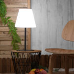 Lampe à poser blanche, abat-jour conique et pied en métal noir sur petite table d'appoint