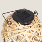 Lampe solaire en rotin beige avec panneau solaire noir et poignée métallique