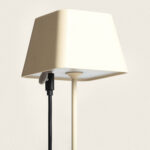 Lampe de table beige à abat-jour carré, tige fine et câble de charge noir visible