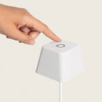 Lampe à poser blanche compacte avec bouton tactile circulaire sur le sommet et câble d'alimentation