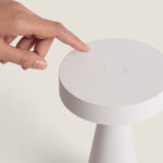 Lampe à poser blanche, plateau circulaire, base conique et commande tactile sur le dessus