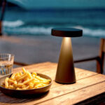 Lampe à poser noire conique avec abat-jour plat émettant lumière chaude