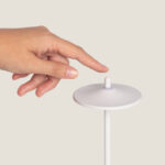 Lampe à poser blanche en métal, plateau circulaire, tige fine et petit bouton au sommet