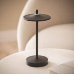 Lampe à poser noire en métal avec abat-jour plat circulaire, tige fine et socle rond