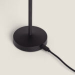 Lampe à poser noire en métal, base ronde avec tige verticale et câble de charge branché