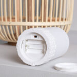 Lampe à poser blanche cylindrique en rotin synthétique avec compartiment piles visible