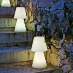 Lampe à poser blanche opaline, forme champignon, lumière diffuse, posée sur marches extérieures