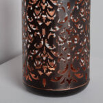 Lampe à poser cylindrique en métal ajouré noir, intérieur cuivré avec motifs floraux découpés