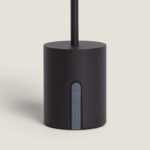 Lampe à poser noir à base cylindrique, tige verticale et bouton latéral