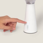 Lampe à poser blanche conique en plastique avec bouton de commande sur la base