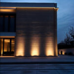 Projecteur linéaire wallwasher extérieur, lumière chaude, faisceaux verticaux éclairant façade en béton