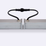 Projecteur linéaire en aluminium argenté, profil rectangulaire, câble de connexion noir et support de fixation