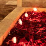 Spot extérieur LED rond émettant lumière rouge, petit, posé sur câble dans paillis de jardin