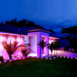 Spot extérieur LED au sol, lumière rose magenta illuminant façade et massifs