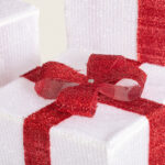 Boîte cadeau blanche avec ruban rouge pailleté et nœud scintillant