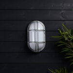 Hublot extérieur ovale en acier galvanisé, diffuseur blanc opalin et grille, fixation murale