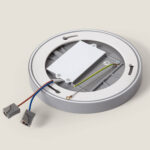 Plafonnier LED rond gris avec boîtier d'alimentation et câbles de connexion visibles