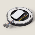 Plafonnier LED rond noir avec boîtier pilote blanc et câbles de connexion visibles