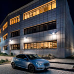 Projecteur mural extérieur monté en applique, éclairage directionnel descendant illuminant la façade d'un immeuble la nuit