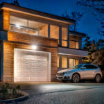 Projecteur LED extérieur mural rectangulaire blanc éclairant une porte de garage la nuit