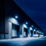 Projecteurs extérieurs LED muraux rectangulaires émettant lumière blanche froide, installés sur la façade d'un entrepôt