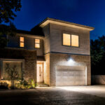 Projecteur LED extérieur mural noir rectangulaire éclairant l'entrée et le garage la nuit