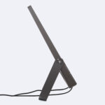 Projecteur LED au corps métal gris foncé, tête profilée, bras articulé et câble d'alimentation