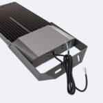 Projecteur LED gris métal, ailettes thermiques, support orientable, câbles de raccordement visibles