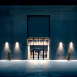 Projecteur mural extérieur éclairant l'entrée d'un bâtiment avec faisceau lumineux chaud