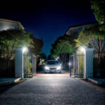 Projecteur LED blanc fixé sur piliers éclairant l'allée d'entrée, faisceau large