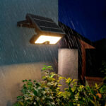 Projecteur LED solaire mural noir avec panneau solaire intégré et détecteur PIR, éclairage chaud sous la pluie