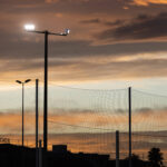 Projecteur LED extérieur sur mât métallique, tête rectangulaire orientable, éclairage pour terrain sportif au crépuscule