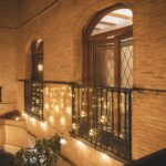 Rideau de boules LED suspendues, globes en verre lumineux couleur chaude, installé le long d'une balustrade extérieure