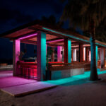 Ruban LED RGBW extérieur éclairant une pergola et terrasse en nuances rose et turquoise