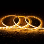 Ruban LED flexible blanc chaud 2700K enroulé, éclairant sur surface humide avec gouttes d'eau