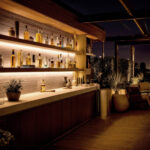 Ruban LED extérieur blanc chaud installé sous étagères de bar sur terrasse